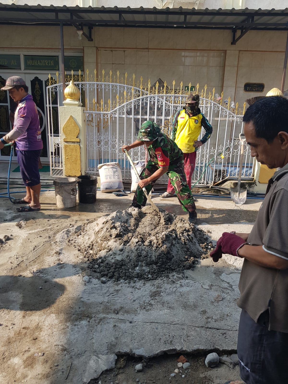 Babinsa Bersama Warga Gotong Royong Pengocoran Lantai Halaman Masjid Al Muhajirin